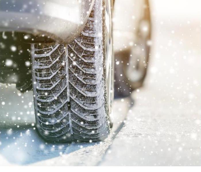 a close-up image of a car and tire moving through snow