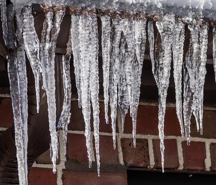 icicles hanging on gutters of red brick house