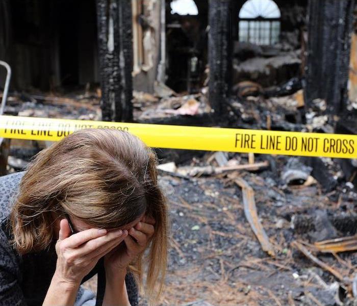 < img src =”housefire.jpg” alt = “woman with hands covering face upset with burnt house in background ” >